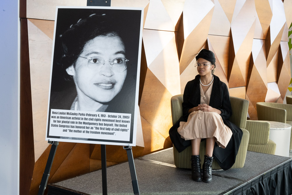woman sitting next to Civil Rights educational sign